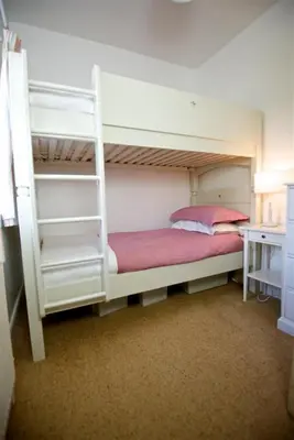a bedroom with two bunk beds with a ladder at Threaby Cottage in Girthon