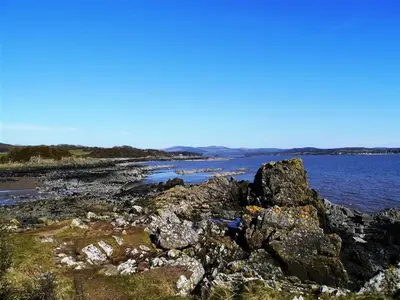 a group of rocks on the shore of a body of water at Threaby Cottage in Girthon