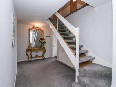 a staircase in a house with a mirror and a chair at Eildon Lodge in Seascale
