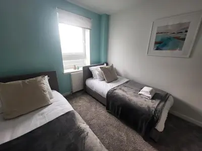 a room with two beds and a couch and a window at River Ayr View-Coorie Doon Stays in Ayr