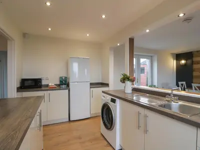 a kitchen with a white refrigerator and a dishwasher at Swallow Cottage in Dumfries
