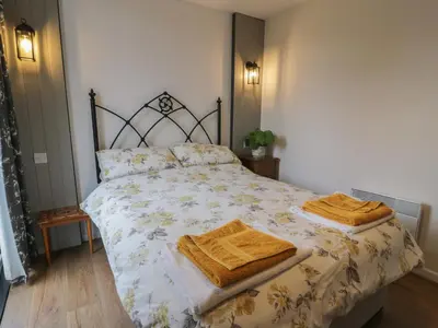 a bedroom with a bed with two towels on it at Swallow Cottage in Dumfries