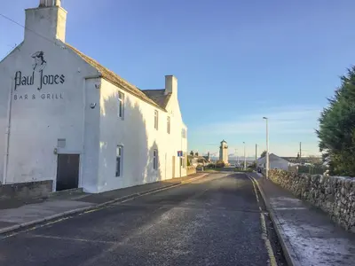 a building with a sign on the side of a street at Swallow Cottage in Dumfries