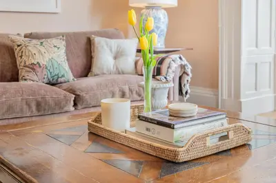 a living room with a coffee table with books and flowers at Huntingstile South in Ambleside