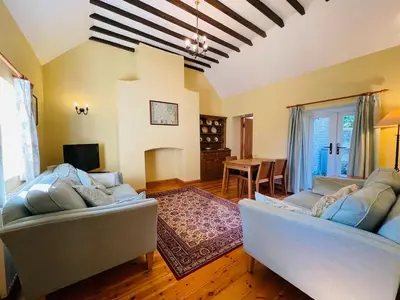 a living room with two couches and a table at Quaint Oxfordshire cottage on a peaceful farm in Moffat
