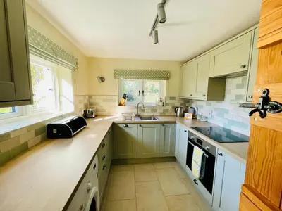 a kitchen with white cabinets and a sink at Quaint Oxfordshire cottage on a peaceful farm in Moffat