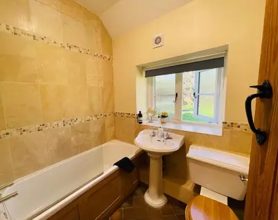 a bathroom with a sink and a bath tub at Quaint Oxfordshire cottage on a peaceful farm in Moffat
