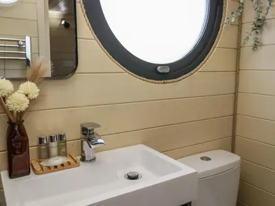 a bathroom with a sink and a mirror and a toilet at Binsey Lodge in Wigton