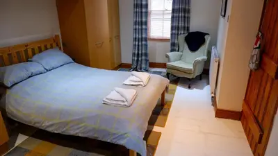 a bedroom with a bed with two towels on it at 9 Millburn Street in Kirkcudbright