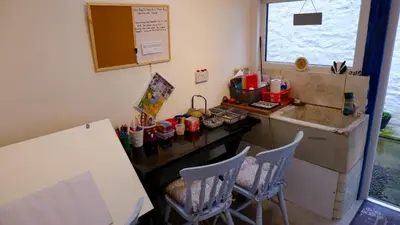 a kitchen with a table and chairs and a counter at 9 Millburn Street in Kirkcudbright