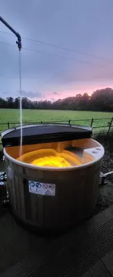 a fire pit with a water fountain in a field at The Tranquil Orchard in Dumfries