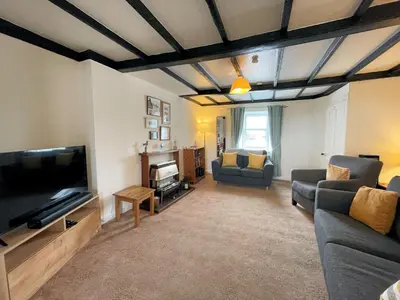 a living room with a couch and a flat screen tv at Traditional Cottage with Beautiful Views - Pass the Keys in Isle of Whithorn