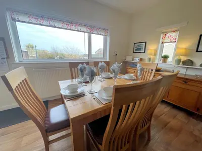 a dining room with a wooden table and chairs at Traditional Cottage with Beautiful Views - Pass the Keys in Isle of Whithorn