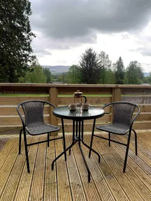 a table and two chairs on a deck at The Woodhouse Cabin 8 in Moffat
