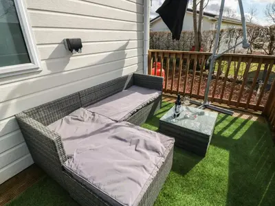 a porch with two wicker chairs and a table at New Horizon in Carlisle