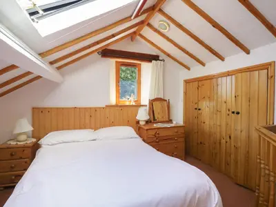 a bedroom with a white bed and a window at Wren's Nest in Keswick