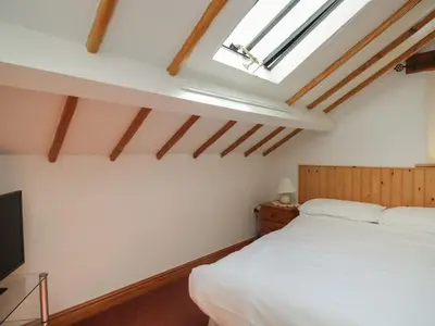 a bedroom with a white bed and a skylight at Wren's Nest in Keswick