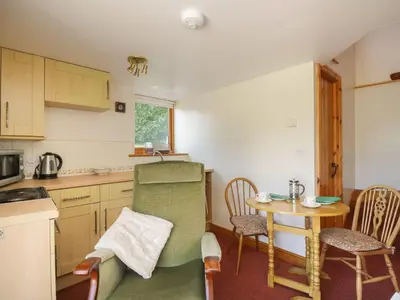 a small kitchen with a table and chairs in it at Wren's Nest in Keswick