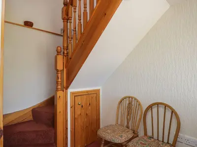 a stairway with two chairs and a wooden staircase at Wren's Nest in Keswick