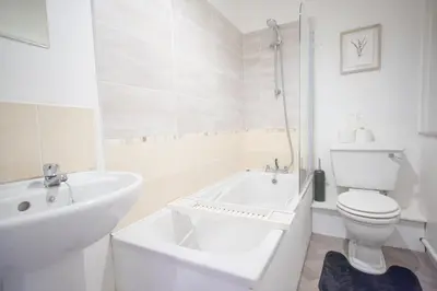 a white bathroom with a tub and a toilet and a sink at Open House in Carlisle
