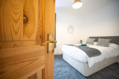 a door leading into a bedroom with a bed at Open House in Carlisle