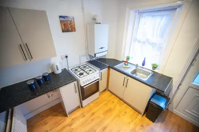 a small kitchen with a stove and a sink at Open House in Carlisle