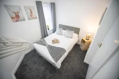 a small bedroom with a white bed and a window at Open House in Carlisle