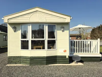 a small house with a large window and an umbrella at Penny in Whithorn