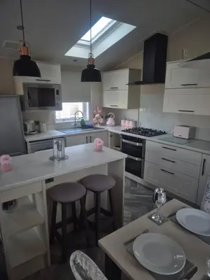 a kitchen with a counter and two stools in it at 2 bedroom platinum in Minishant