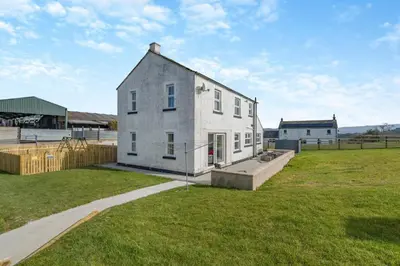 a large white house in a grassy field at 3 Bed in Cockermouth oc-o31515 in Embleton
