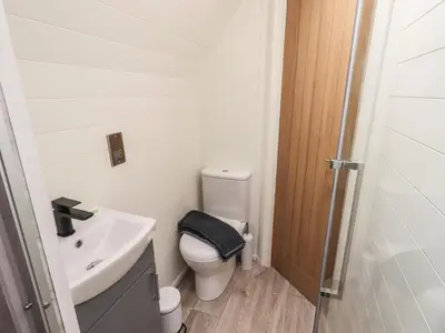 a small bathroom with a toilet and a sink at Shepherds View in Keswick