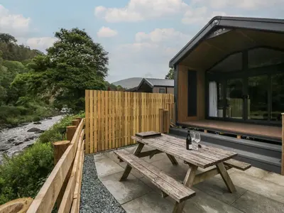 a wooden picnic table on the patio of a house at Sail Luxury Family Pod in Keswick