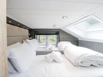 a bedroom with two beds and a skylight at Sail Luxury Family Pod in Keswick