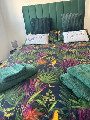 a bedroom with a bed with a tropical themed bedspread at Saltayr in Ayr