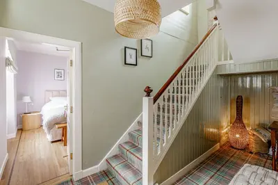 a bedroom with a staircase and a bed with a guitar at Hightae B&B in Hightae