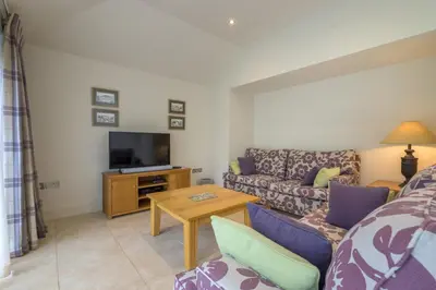 a living room with a couch and a tv at The School at Mungrisdale in Penrith
