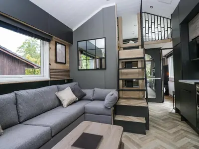 a living room with a couch and a book shelf at Dubs Luxury Family Pod in Keswick