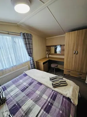 a bedroom with a bed and a desk at The Canny View at Three Lochs Holiday Park in Balminnoch 3 bedroom sleeps upto 8 guests in Newton Stewart