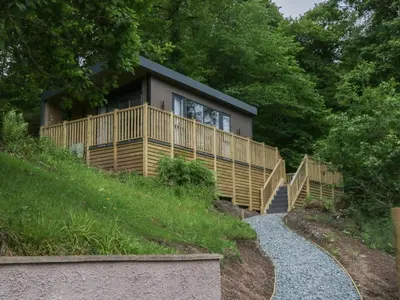 a house on the side of a hill with a walkway at Hodge Luxury Pod in Keswick
