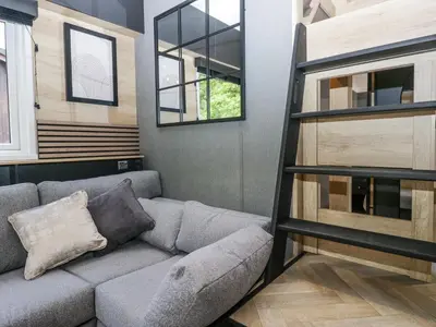 a living room with a couch and a window at Woof Luxury Family Pod in Keswick