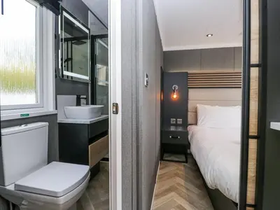 a bathroom with a bed and a sink and a toilet at Lingy Luxury Family Pod in Keswick
