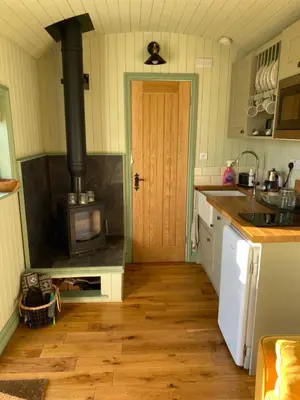 a kitchen with a woodburning stove in a kitchen at Sunset Snug Shepherd hut in Penrith