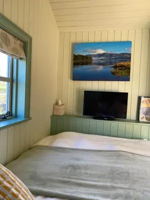 a bedroom with a bed and a tv on a wall at Sunset Snug Shepherd hut in Penrith