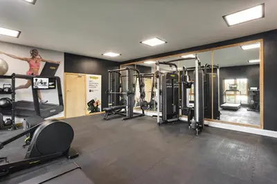 a woman is in a gym with several machines at The Sanctuary - Ridgestone in Watermillock