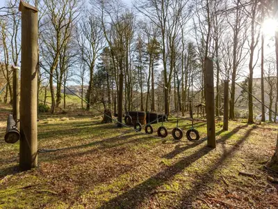 a fence with a horse pulling a cart in a field at Villa Rabbie Burns Lodge by Interhome in Straiton