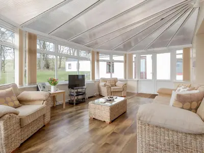 a living room with couches and a tv at Holiday Home Balcraig House by Interhome in Straiton