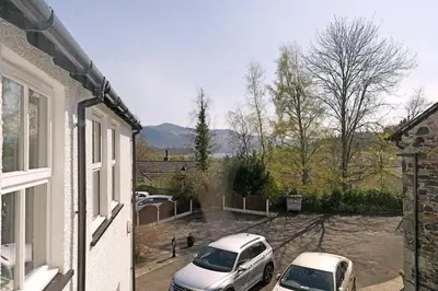 two cars parked in a parking lot next to a house at 6 Harney Peak in Portinscale
