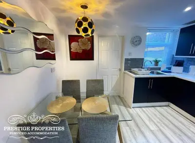 a kitchen with a table and chairs in a room at Victoria Place by Prestige Properties SA in Workington