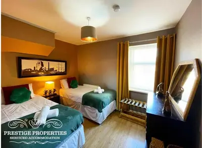 a hotel room with two beds and a mirror at Victoria Place by Prestige Properties SA in Workington