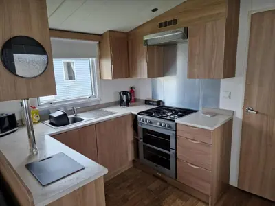 a kitchen with wooden cabinets and a stove top oven at Manannan in Maryport